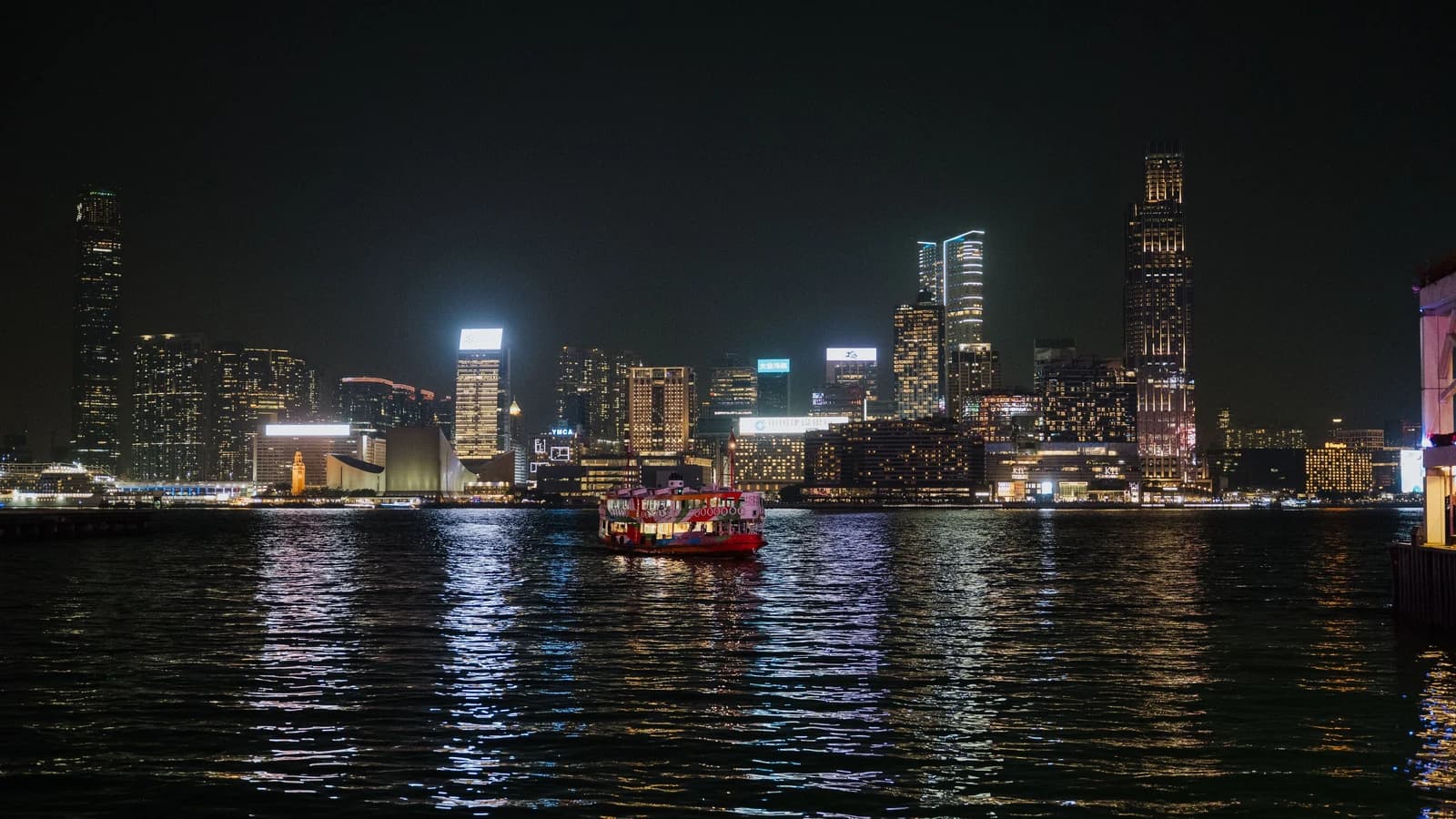 Hong Kong skyline at night with illuminated ferries on Victoria Harbour