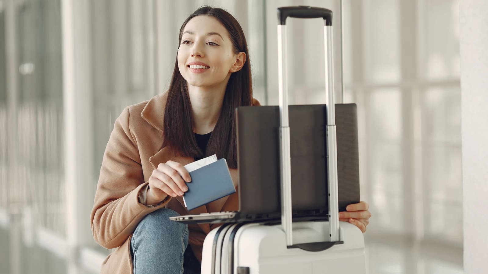 Traveler checking a laptop with a passport at an airport