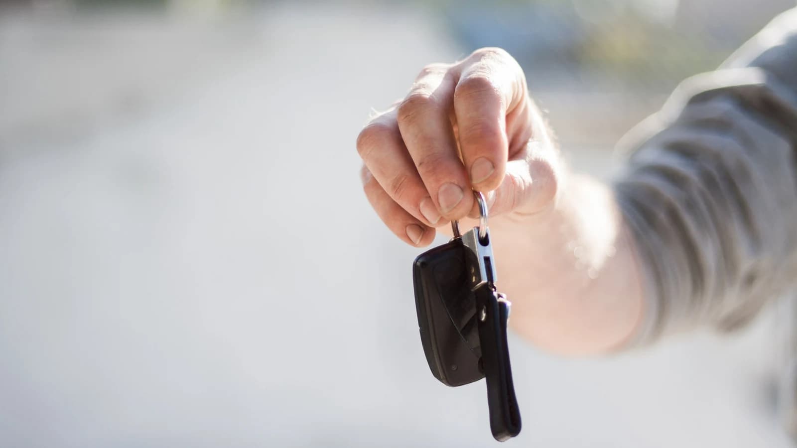 Close-up of a person handing over car keys