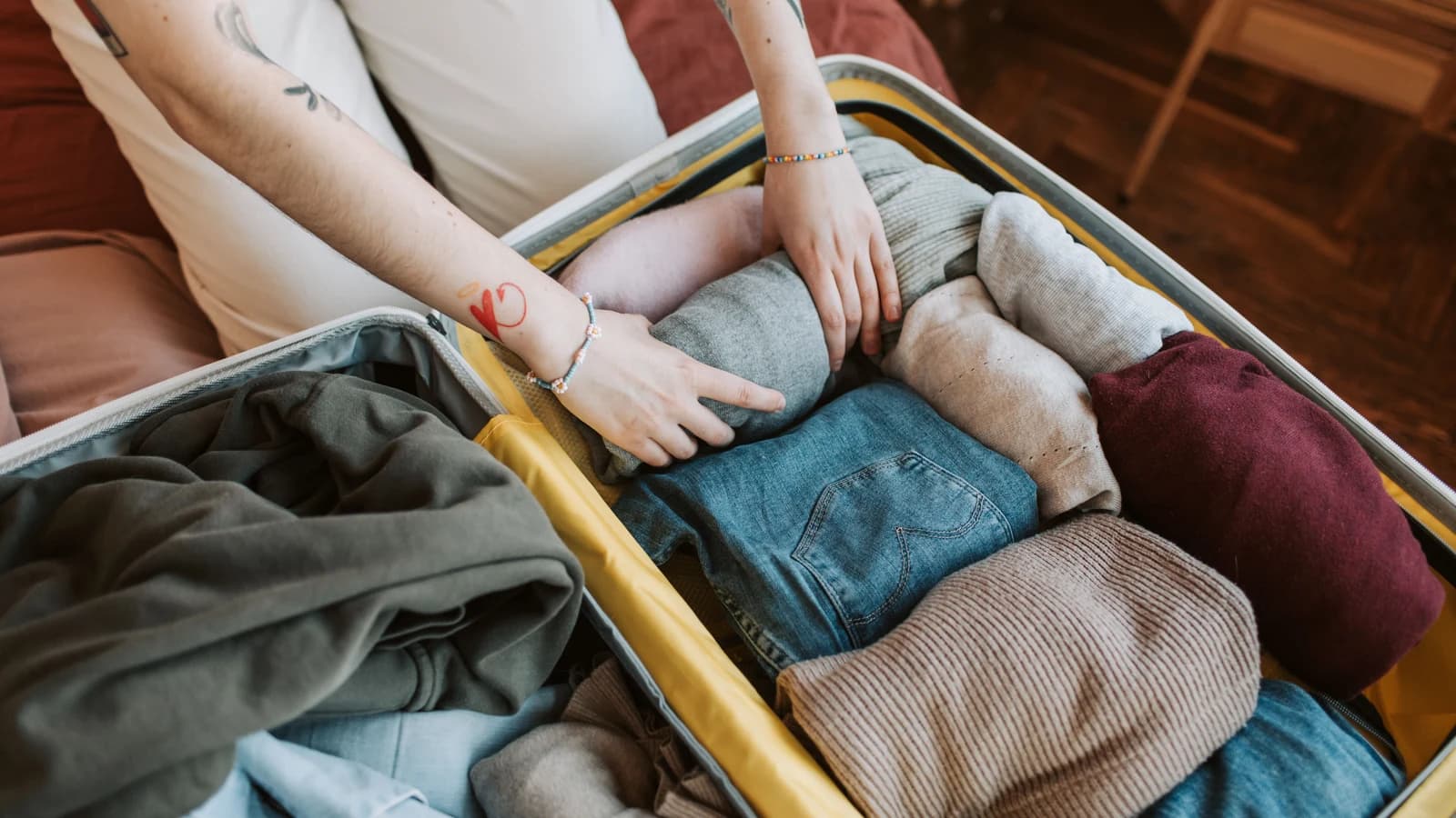Hands packing clothes into a suitcase