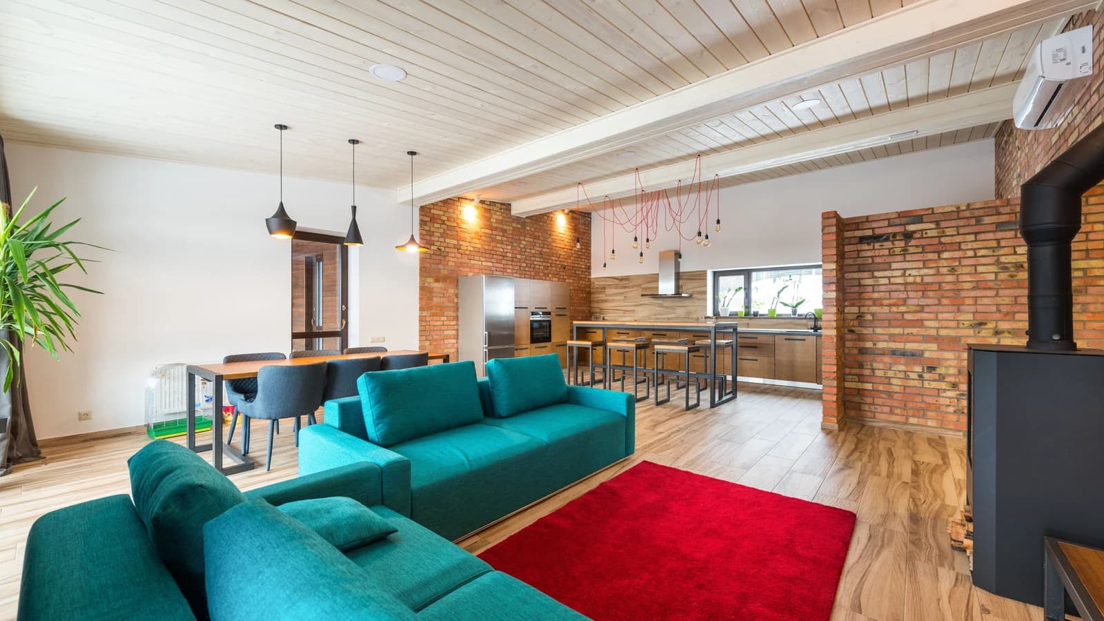 Modern apartment with a teal sofa and brick wall