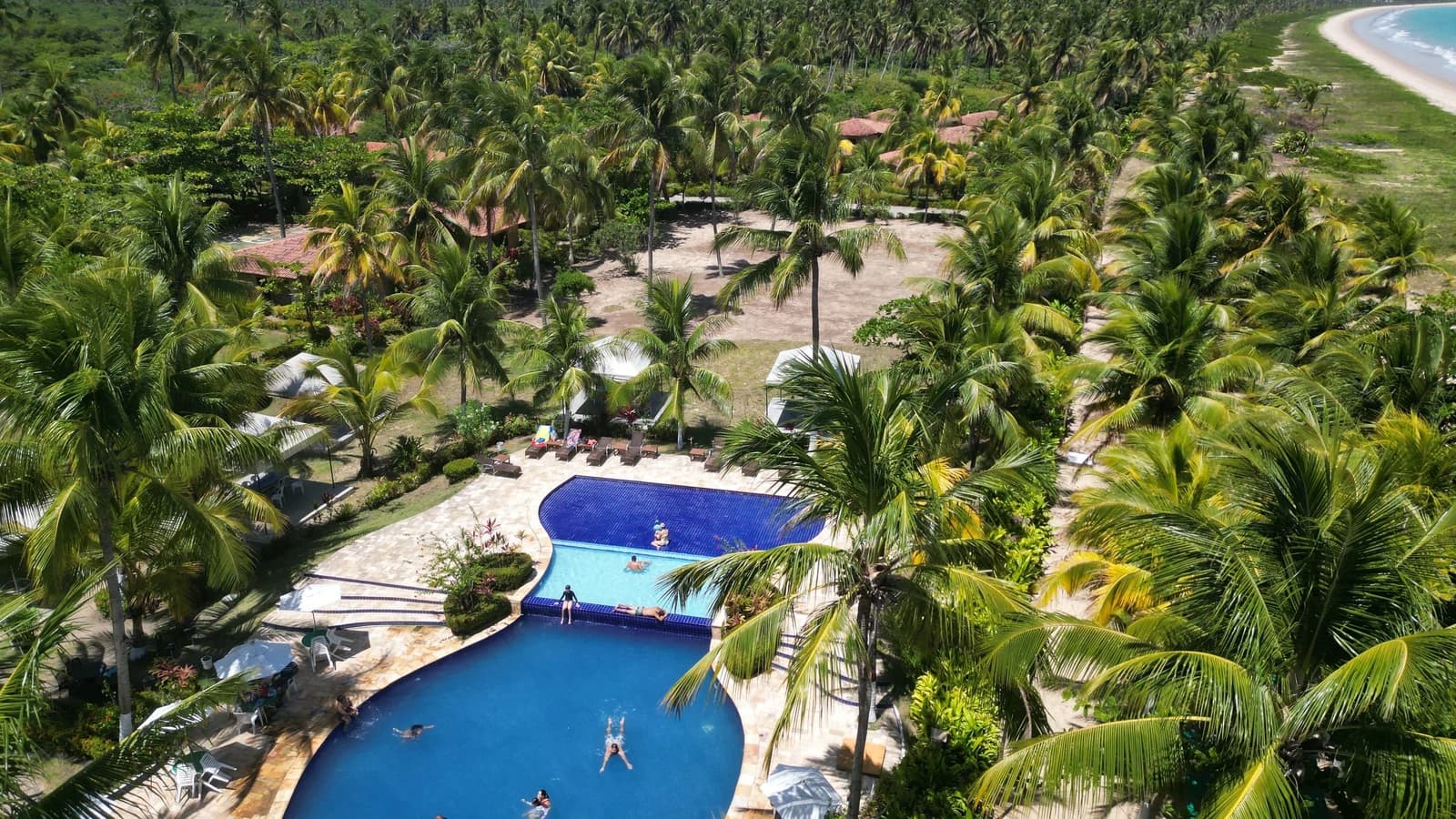 Aerial view of a tropical beachfront resort and pool