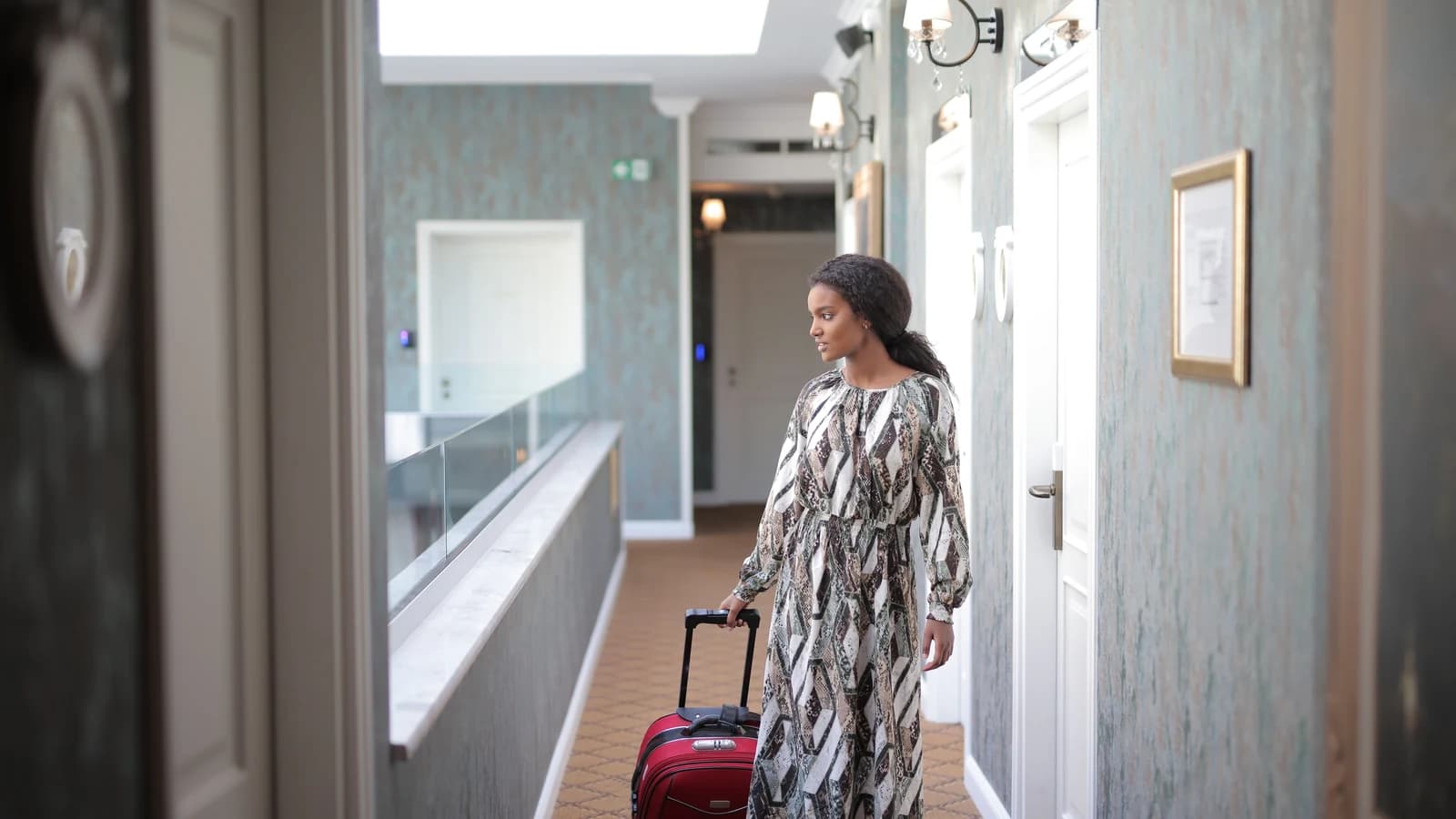 Woman pulling a suitcase along a hotel corridor