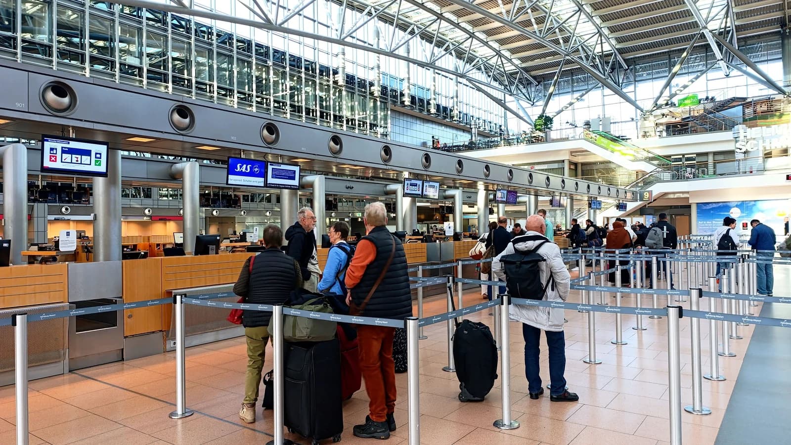 Travelers queuing in the check-in area at Hamburg Airport, Germany