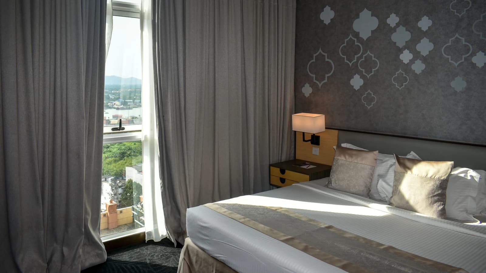 Hotel bedroom with a large window overlooking a mountain landscape